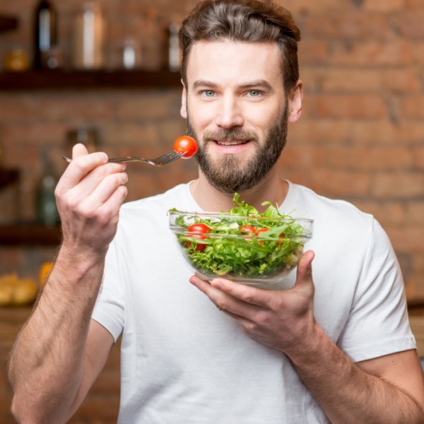 Hombre comiendo saludable: Alimentos que causan impotencia masculina.